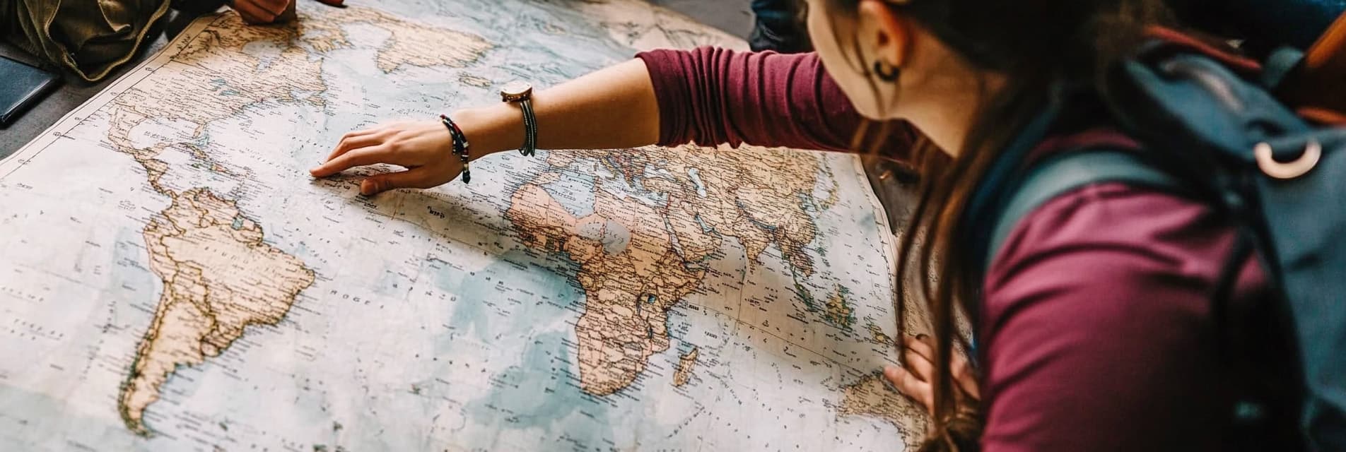 Digital Nomad Planning a Trip on a World Map
